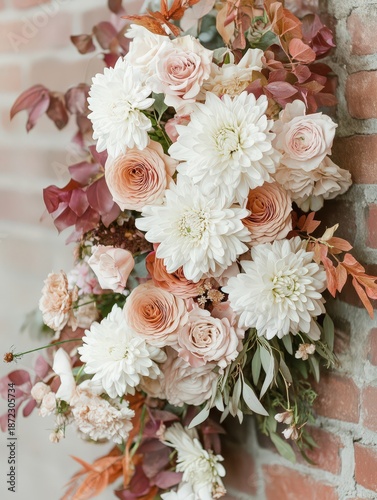 Elegant bouquet of white chrysanthemums and pink roses arranged against a rustic brick wall for a stunning decor display