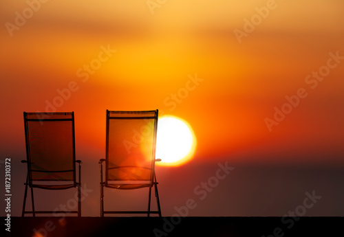 Zwei sonnenstühle vor einem paradiesischem Sonneuntergang am Meer