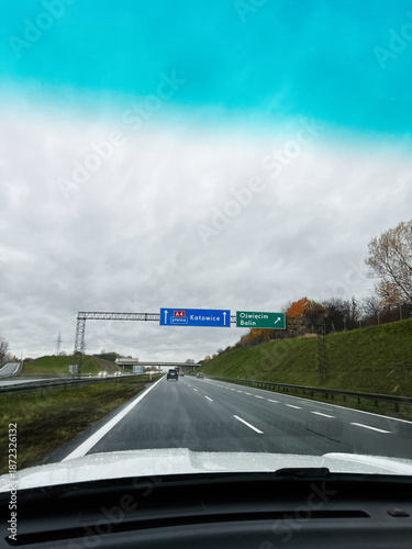 Obraz na plátně On a cloudy highway a driver sees Katowice and Oswiecim signs guiding the route