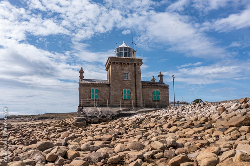 Historic Blacksod Lighthouse stands prominently on foundation coast against vibrant blue sky in County Mayo Ireland
