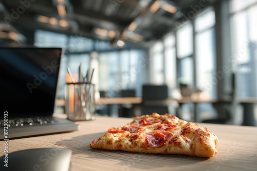 Fresh pizza on office desk with laptop
