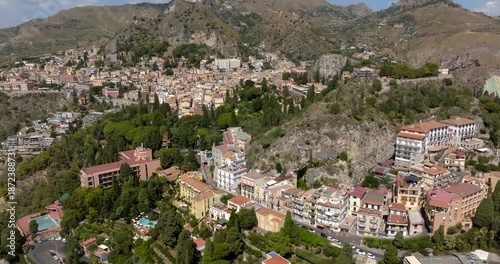 Aerial view of the town of Taormina, in the province of Messina, Sicily, Italy. It is a picturesque town nestled in the Sicilian Nebrodi mountains. It is a sunny day morning. 