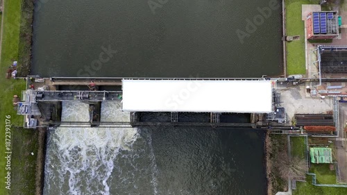 Aerial view of Colwick Sluice where the flowing water contrasts with the dark water and green banks, Colwick, Nottingham, United Kingdom.