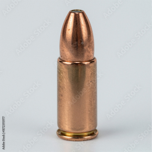 Close-up of a copper hollow-point bullet seated in a cartridge case, highlighting fine grooves and the hollow tip