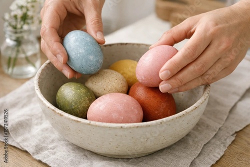 Hands Arranging Naturally Dyed Easter Eggs in a Rustic Bowl