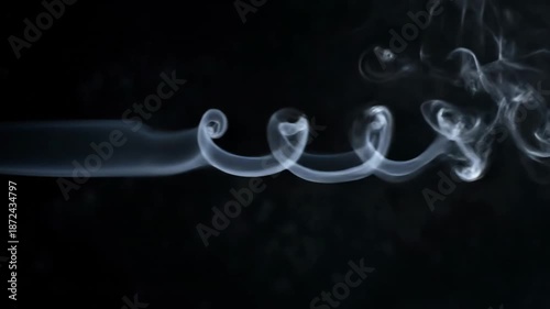Soft flowing smoke forming elegant abstract shapes in darkness