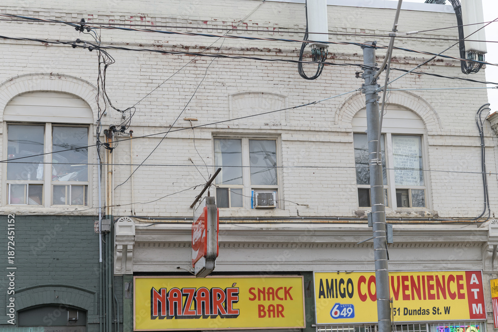 Obraz premium exterior building facade and signs of Nazaré Snack Bar and Amigo Vape & Convenience at 1151 Dundas St W, Toronto