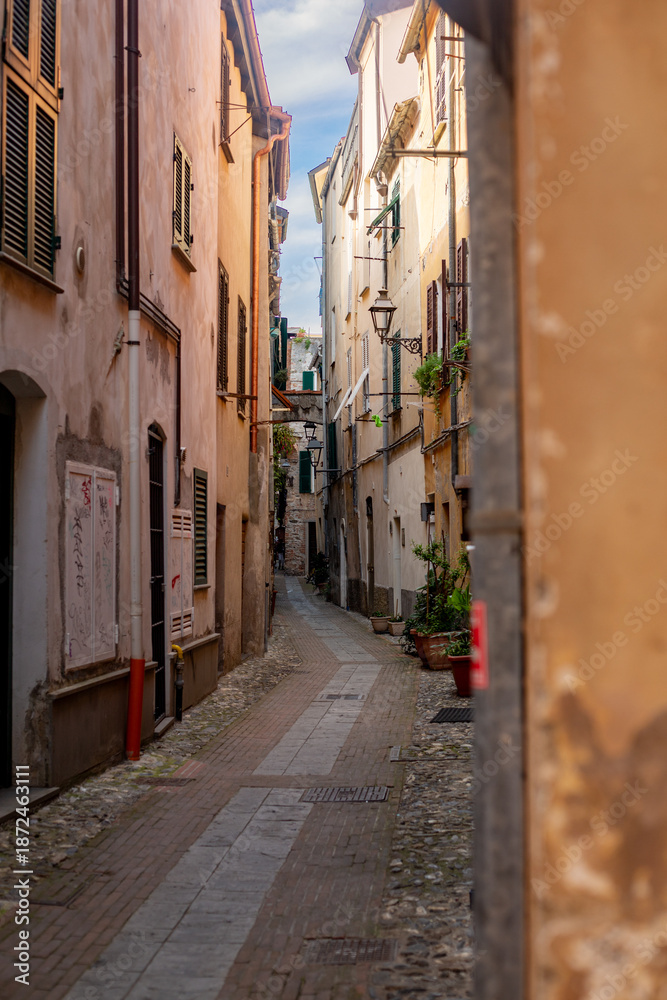 Obraz premium Albenga, Liguria, Italy - August 19, 2025 Medieval houses in Albenga, characterized by narrow alleys called carrugi, and arches, support bridges between the houses in the historic center, in the