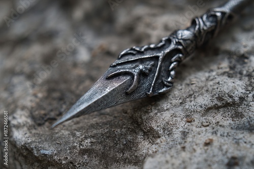 Intricately designed spear displayed on textured stone, invoking fantasy and adventure themes