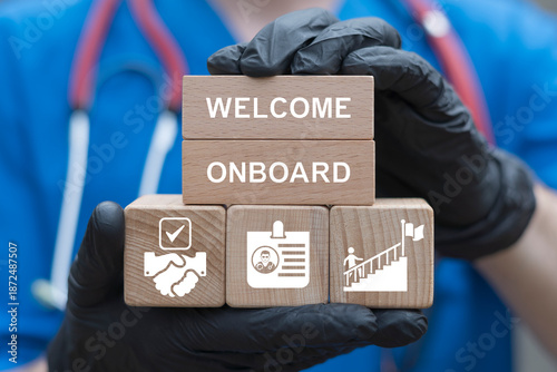 Concept of health care welcome onboard. Doctor holding wooden blocks with icons sees the text WELCOME ONBOARD. Onboarding Medical Management New Employees Process.