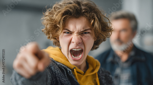 A young man is pointing angrily at something