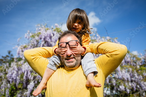 smiling father and daughter in yellow clothes playing together