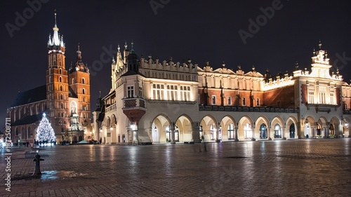 Nocne zdjęcie Krakowa ukazujące oświetlone zabytki, brukowane ulice i klimatyczną atmosferę miasta.