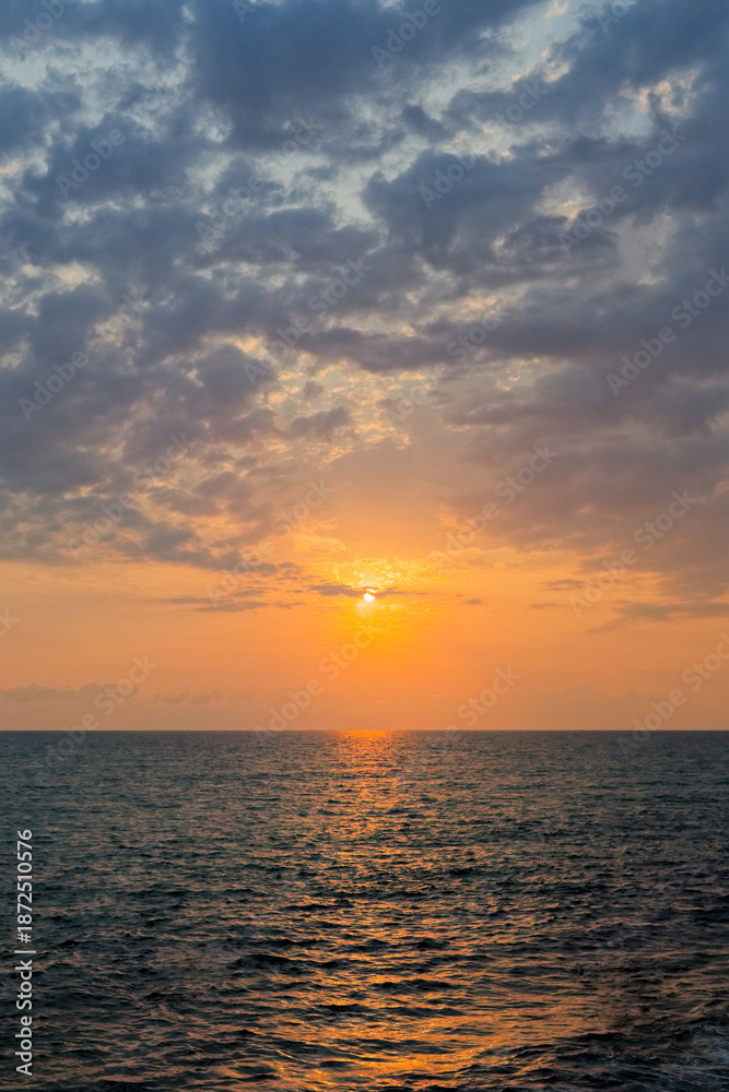 Fototapeta premium Beautiful landscape with bright sunset over the sea. Sea wave and coast in golden hour.