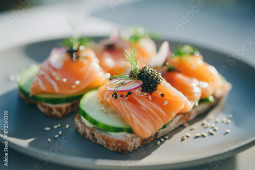 Smoked Salmon Crostini With Cucumber Slices And Black Caviar Garnish On A Gray Plate