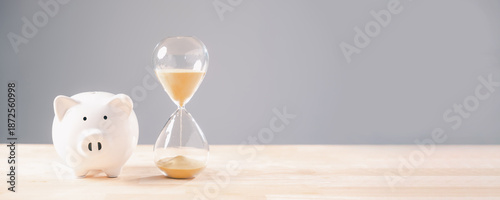 Bilde på lerret Piggy bank and hourglass symbolize saving money over time, important financial p