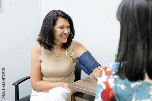 Senior womans arm fitted with cuff to check blood pressure