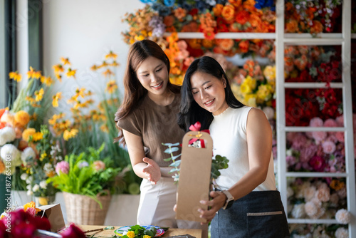 Cuadro en lienzo Florist helping customer choosing flower bouquet in shop