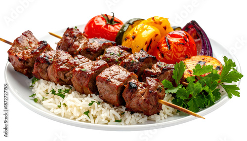 Grilled meat skewers with colorful roasted vegetables and white rice on a white plate