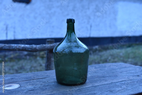 Фотография Vintage green glass demijohn bottle
