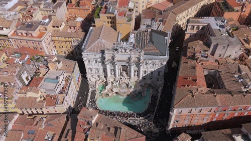 Vertical top down aerial view of Trevi Fountain in Rome Italy, iconic baroque landmark surrounded by historic buildings, tourists and narrow streets captured from drone perspective