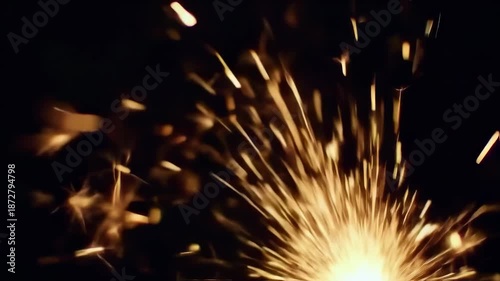 Close-up of golden sparks radiating outwards against a dark background, creating dynamic visual interest