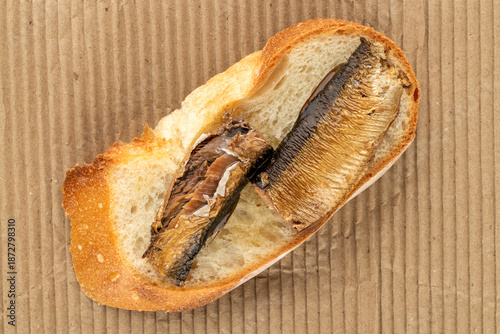 Tablou pe pânză Sprat sandwich on kraft paper, top view, macro.