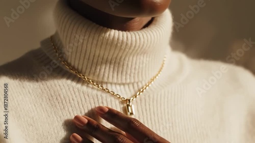 Woman wearing white turtleneck and gold necklace with pendant