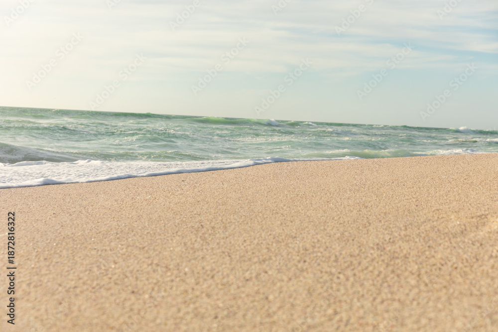 Fototapeta premium Beautiful horizon over sea with waves splashing on shore at sunny beach against sky