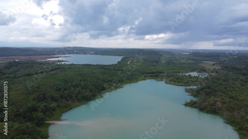 Aerial view of a former coal mining pit that holds water like a blue lake, environmental damage