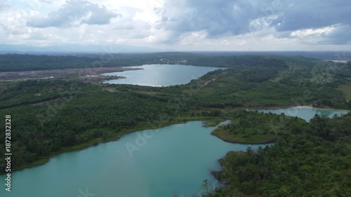 Aerial view of a former coal mining pit that holds water like a blue lake, environmental damage