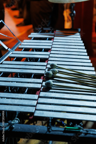 Vászonkép A vibraphone rests on stage under warm lights, mallets placed across metal bars,