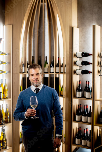 Man holds wine glass in mod...