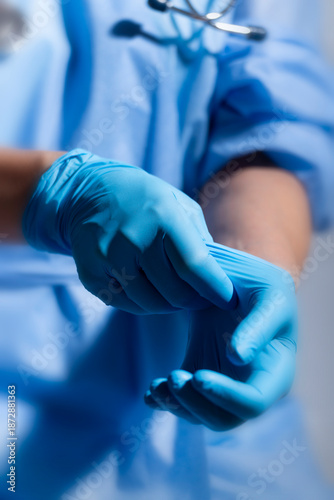 Healthcare professional putting on blue medical gloves on white background with copy space