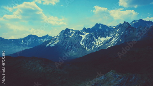 Valokuva Towering peaks rise dramatically against a bright blue sky, their snow caps glistening in the fading light