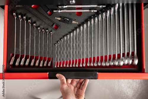Photos Hand opening organized tool drawer with wrench set