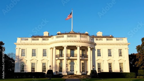 The iconic White House in Washington D.C. under a clear blue sky, showcasing its grand neoclassical architecture and the American flag.