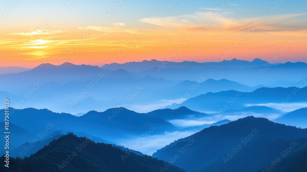 Fototapeta premium panoramic Asian mountains at sunrise, early year atmosphere, subtle fog between hills, pastel orange and blue sky