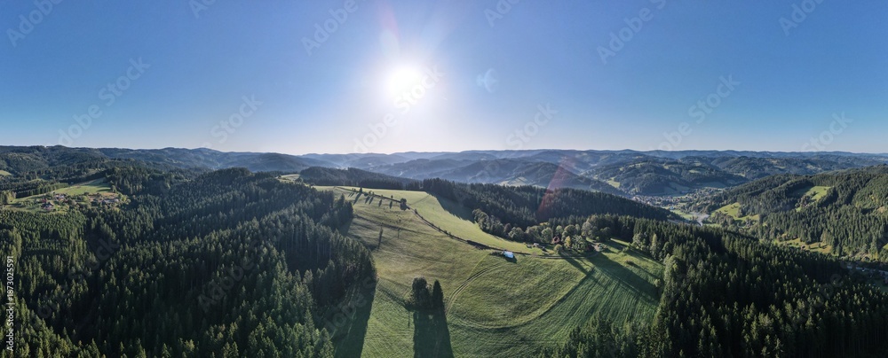 Obraz premium Aerial drone view of the village of Velké Karlovice, Moravia, Czech Republic. Sunny day in the Beskydy Mountains, view of forested hills, meadows and a small town.