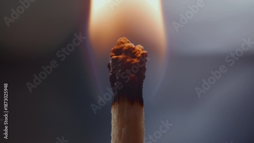 Extreme close-up view of match head being lit with bright flame, then burning and forming glowing halo around charred tip