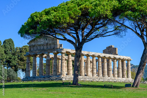 Ancient Greek Temple of Athena in Paestum, Italy at sunny day with blue sky. Famous archaeological site of Paestum, Magna Graecia, ancient ruins.