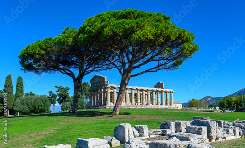 Ancient Greek Temple of Athena in Paestum, Italy at sunny day with blue sky. Famous archaeological site of Paestum, Magna Graecia, ancient ruins.