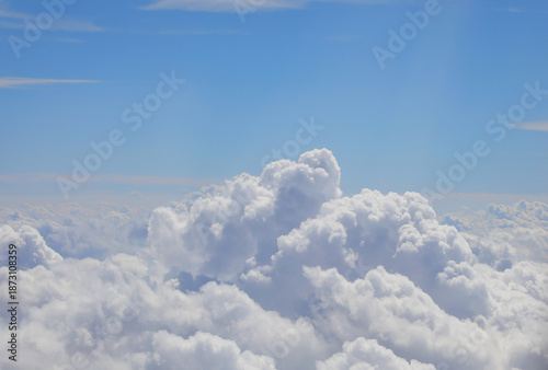 clouds and the blue sky above seen during the flight from an airplane over forty thousand feet altitude
