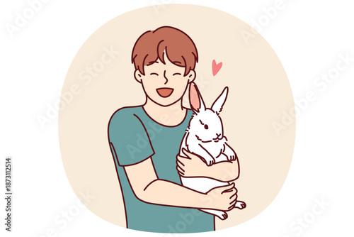 Boy with little rabbit laugh hugging beloved pet for concept of love for domestic animals. Happy child with white eared rabbit for advertising pet store with goods for pets and their owners
