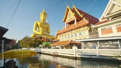 Golden big buddha statue riverside Wat Paknam with wooden boat sightseeing travel in Bangkok Thailand