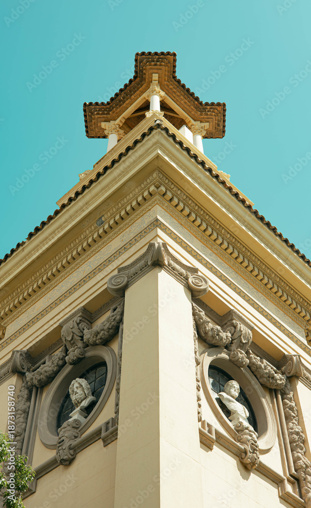 Obraz premium Historic church bell tower, photographed from below. Warm evening light, Mediterranean architecture, calm urban atmosphere. Concept of travel, religion, culture, heritage, and European city life