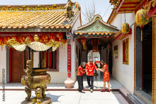 Obraz na plátne Asian family with senior parent in red cheongsam qipao dress is helping the gran