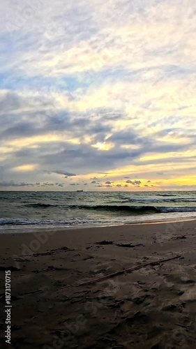 Calm Ocean Shoreline at Sunset with Soft Waves and Cloudy Sky