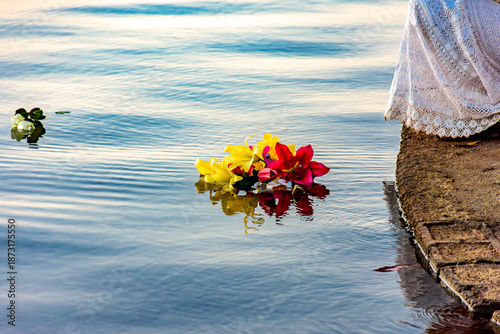Flowers being placed in the water as an offering during a festival honoring Iemanjá, one of the entities of Umbanda.