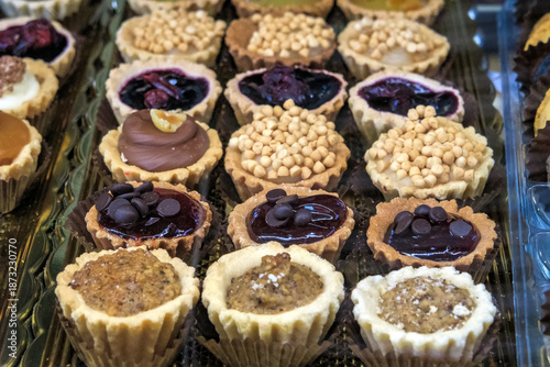 Close-up of an Assortment of Gourmet Mini Tartlets with Chocolate, Jam, and Nut Toppings